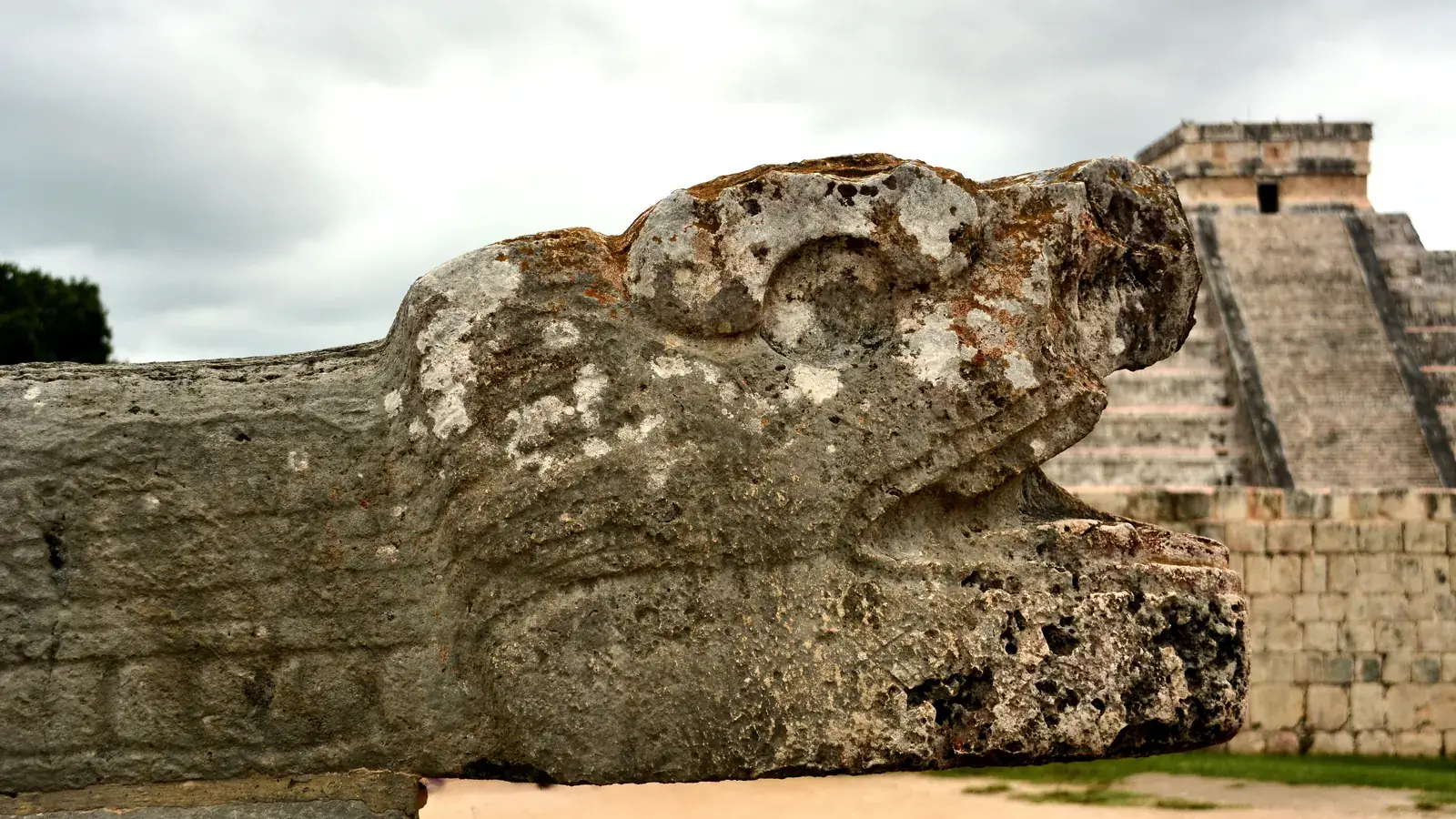 Maya sculpture with the Temple of Kukulkán in the background