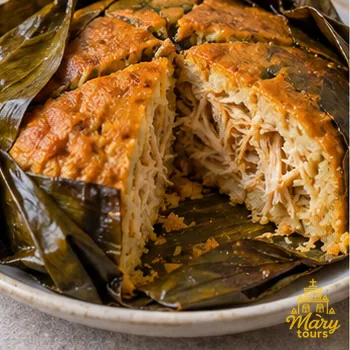 Mucbipollo baked in banana leaves, with one portion cut open